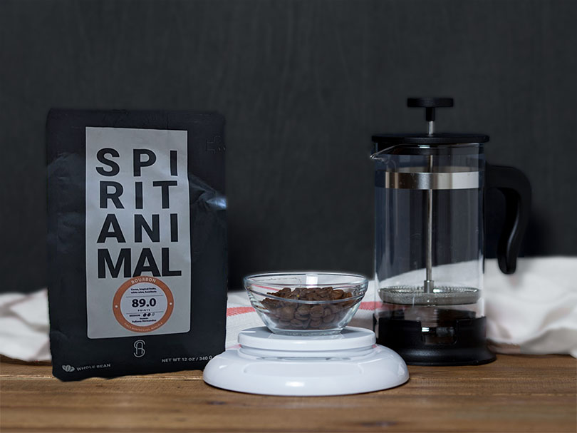 Bag of Spirit Animal (Bourbon) organic coffee beans on table with a French press