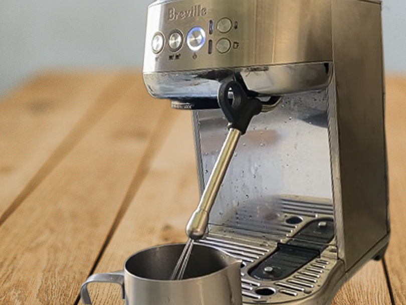 Breville Bambino Plus with water coming out of the 4-hole milk frothing wand