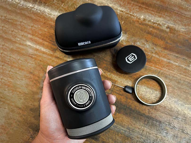 Wacaco Picopresso in hand with its accessories in the background