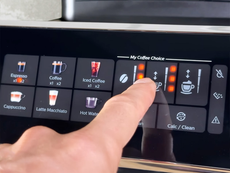 Finger making adjustments to the 'My Coffee Choice' section of the Philips 3300 user interface