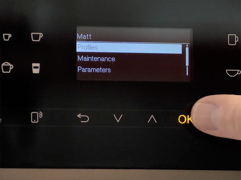 Close-up of the Miele CM 6360's screen showing Matt's user profile, and a thumb hovering over the OK button