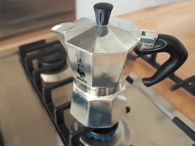 A moka pot (Bialetti Moka Express) on a gas stovetop